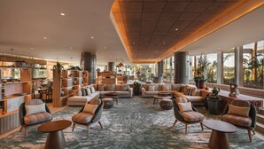A spacious lobby with a central seating area, a bar, and large windows offering views of the outdoors. - Hyatt Regency Vilamoura Algarve (Loule)