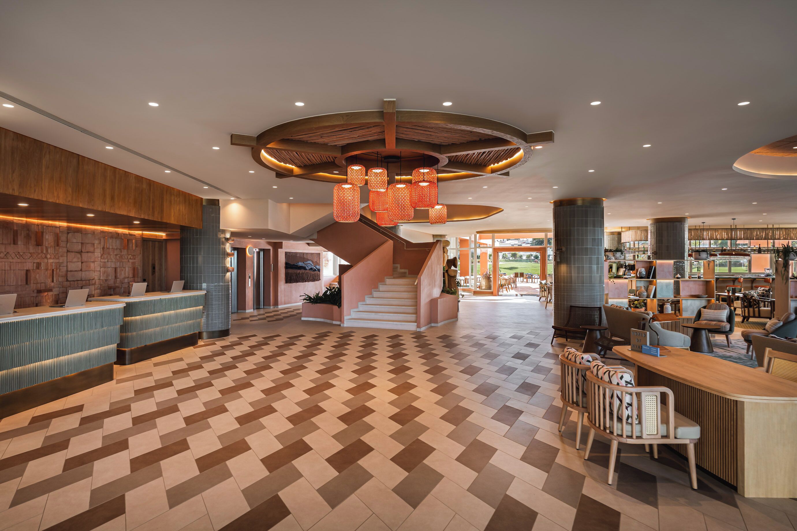 Eine geräumige Lobby mit einer Rezeption, einer Treppe und einer Sitzecke.