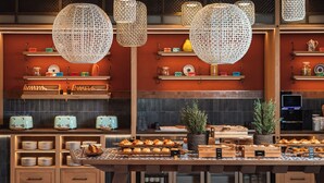 A bakery display with various baked goods and a coffee machine. - Hyatt Regency Vilamoura Algarve (Loule)