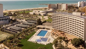 A hotel with a large pool, multiple buildings, and a beach view. - Hyatt Regency Vilamoura Algarve (Loule)