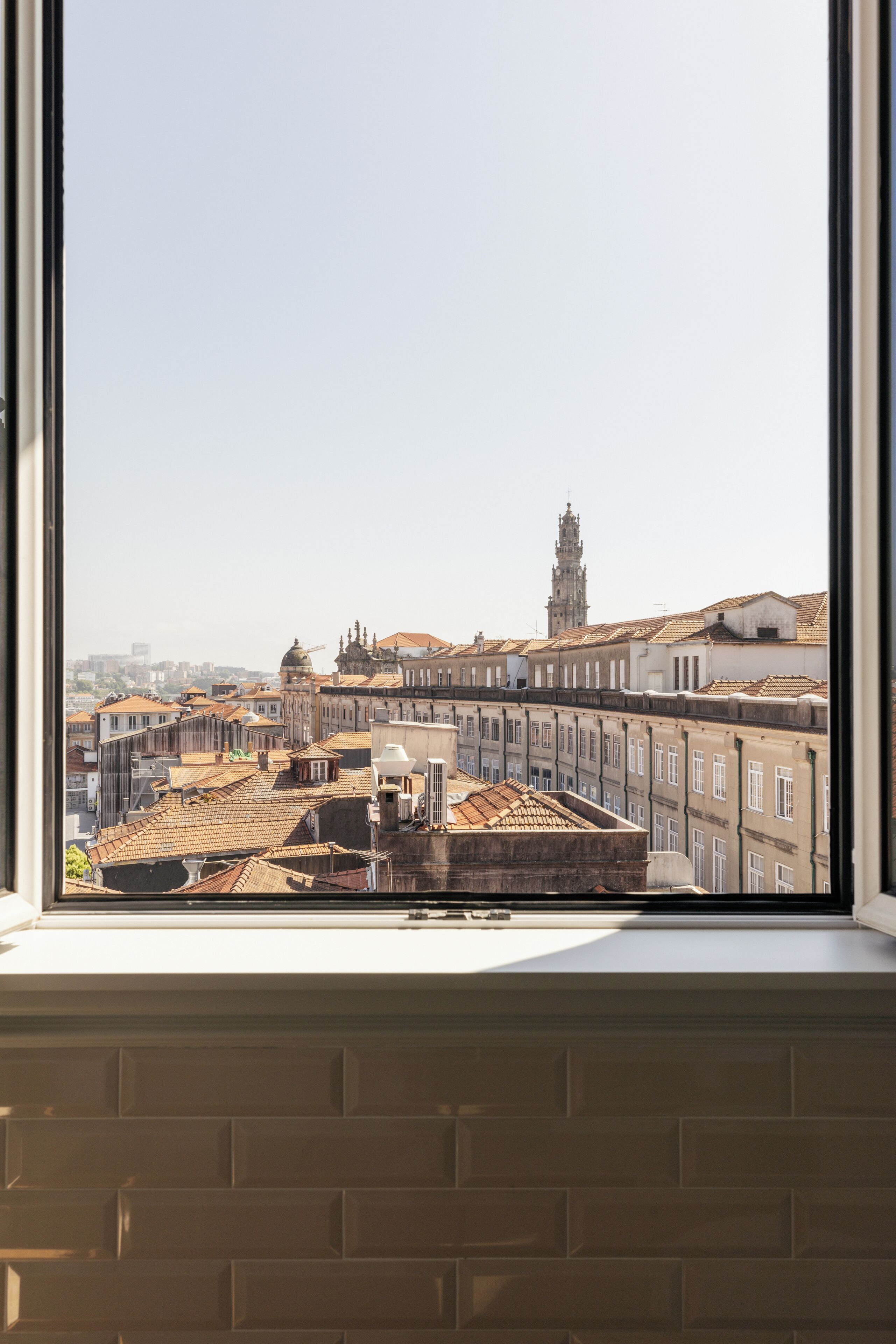 A view through a window of a cityscape with historic buildings and a prominent tower.