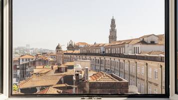 A view through a window of a cityscape with historic buildings and a prominent tower.