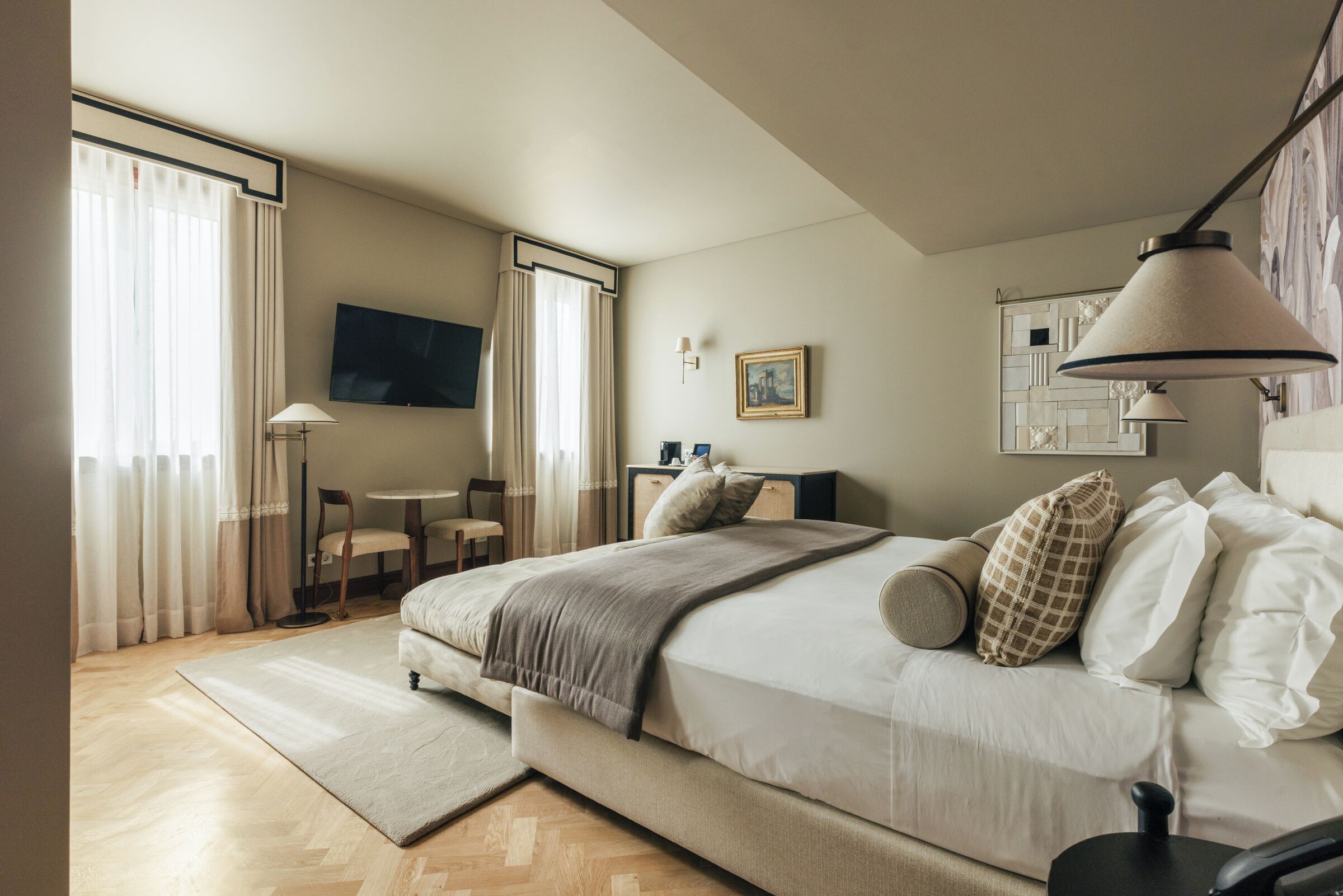 Une chambre d’hôtel moderne équipée d’un grand lit, d’un bureau, d’une chaise et d’un téléviseur.