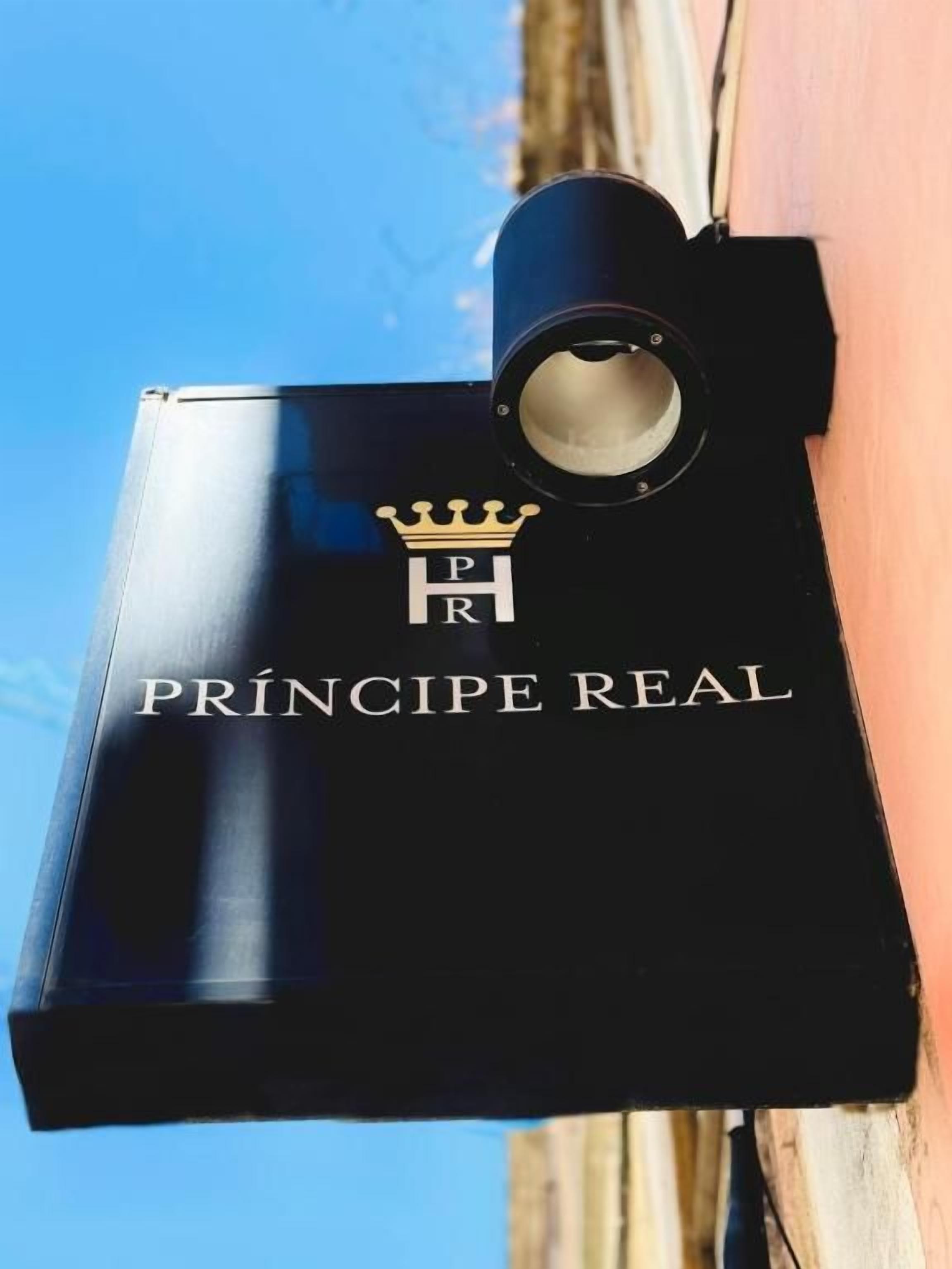 A black object with the text 'PRINCIPE REAL' and a crown symbol.