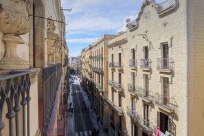 Una calle estrecha bordeada por edificios históricos con balcones y detalles arquitectónicos ornamentales.