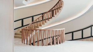 Una escalera de caracol con barandillas de madera y un rellano circular.