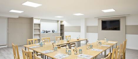 A conference room with a large table, chairs, and a whiteboard.