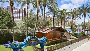 A theme park entrance with a sign for 'Katmandu Adventures' and a play area with a wooden structure and slides. - Sol Pelícanos Ocas (Benidorm)
