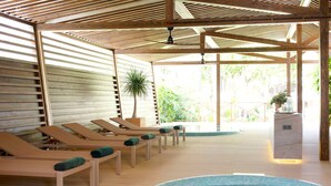 Un área de piscina con sillones de descanso y un jacuzzi.