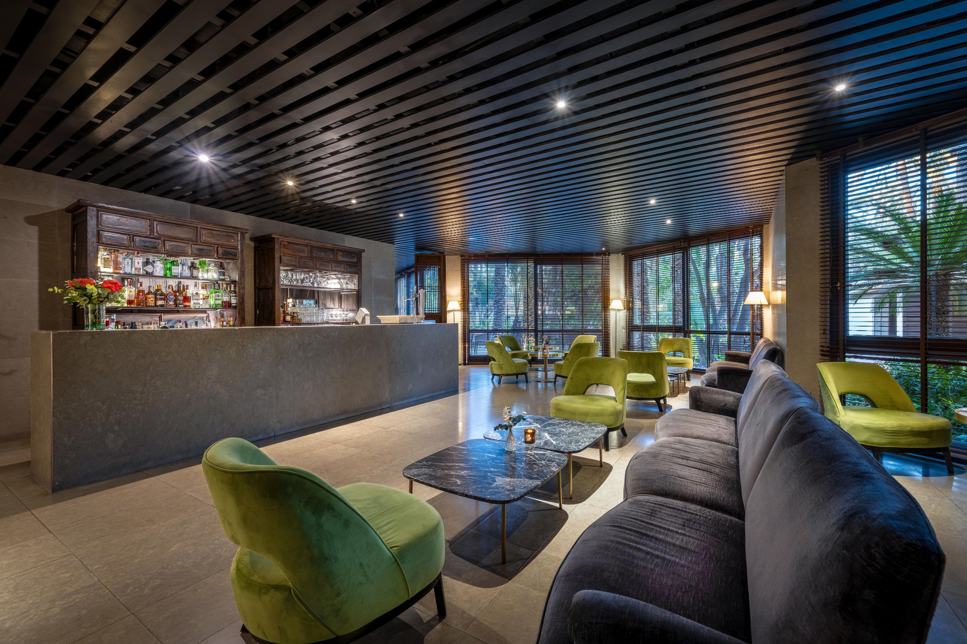 A modern lounge area with a bar, seating, and large windows.