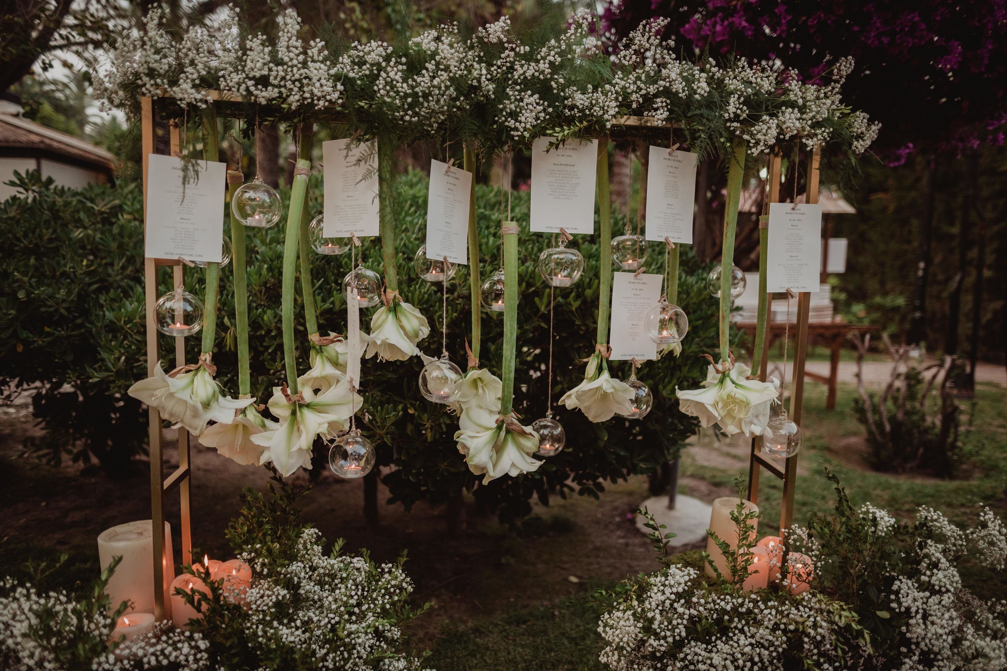Un entorno exterior decorativo con arreglos florales y esferas de vidrio colgantes.