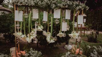 Un entorno exterior decorativo con arreglos florales y esferas de vidrio colgantes.