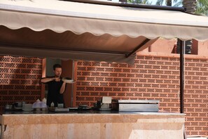 Der serveres frokost og middelhavsretter med udsigt til poolen 