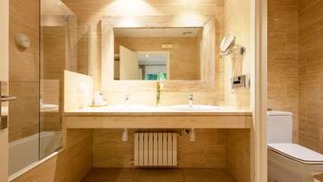 A modern bathroom with a glass-enclosed shower, a double sink vanity, and a toilet.