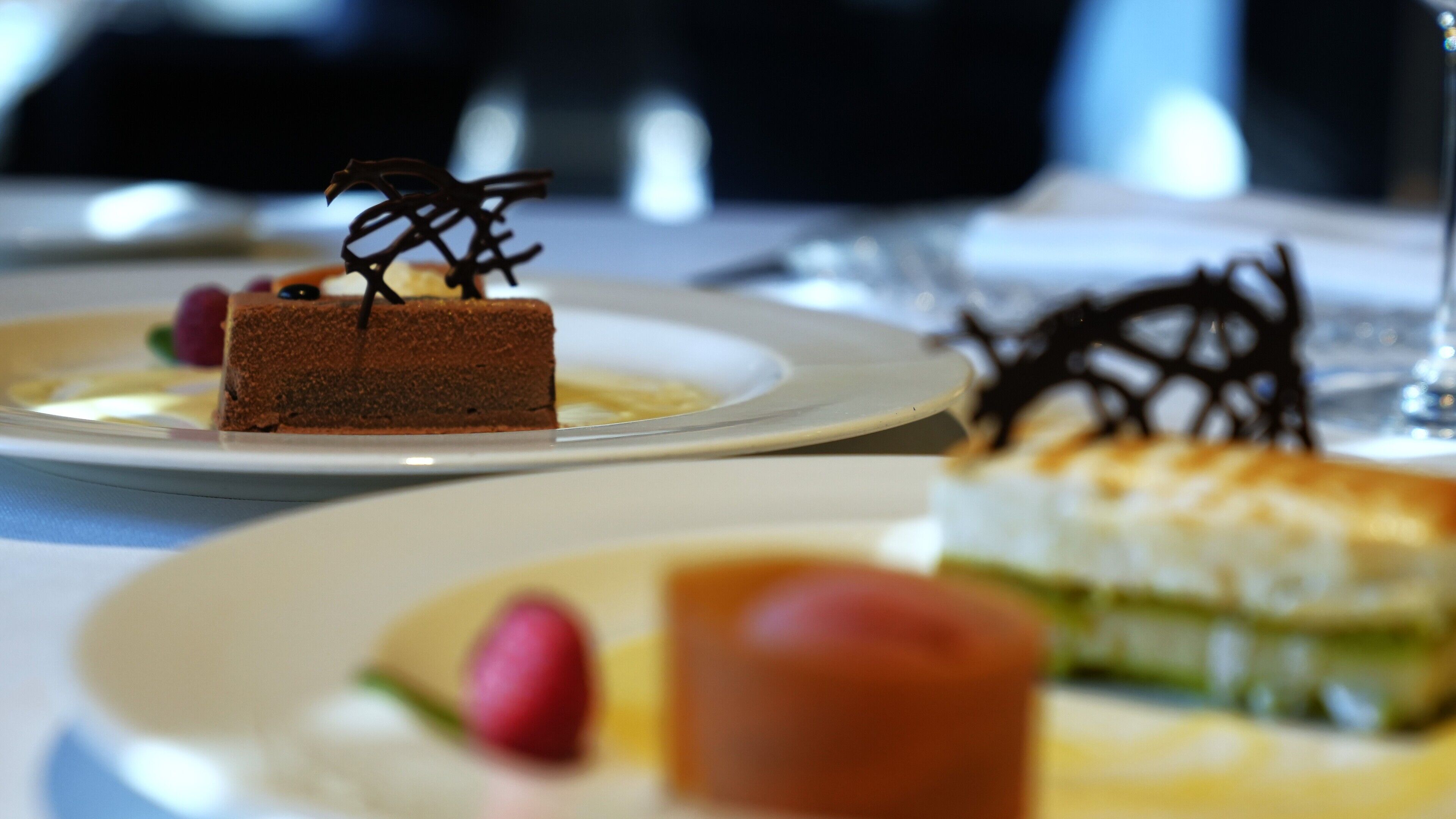 A dessert plate with a chocolate cake and a glass of water.