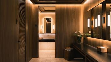 Un baño moderno con paneles de madera, un tocador con espejo y un cesto de basura.