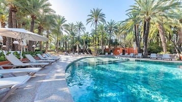 Una piscina al aire libre, tumbonas