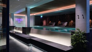 Un moderno espacio de spa con mostrador de recepción, piscina y zona de estar.