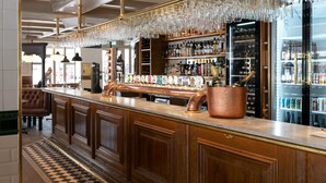 Una zona de bar con un cubo de cobre, una grifería de cerveza y un enfriador de vino.
