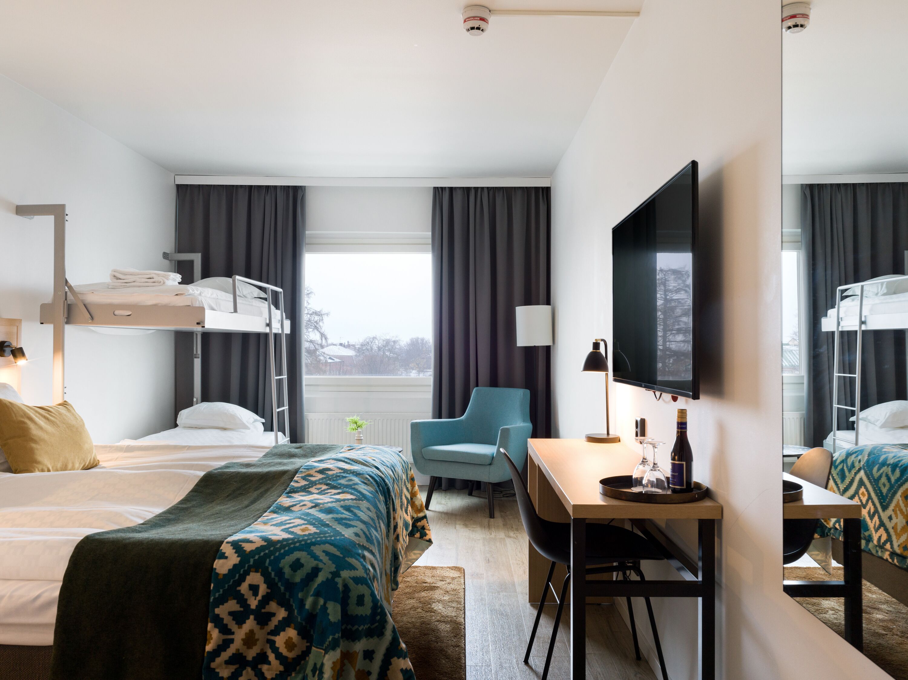 Familjerum | Minibar, skrivbord, arbetsyta för laptop och mörkläggningsgardiner