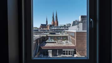 Udsigt gennem et vindue af en bygning med moderne indretning, en trappe og udsigt til en kirke med to tårne.