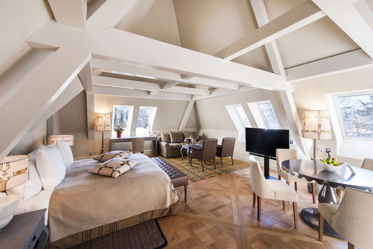 Amplio dormitorio tipo loft con una cama grande, una mesa de comedor y un televisor.