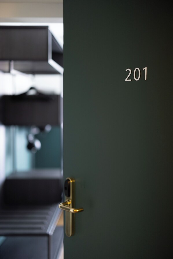 A door with the number 201, a gold handle, and a blurred background suggesting a modern interior. - City Hotel Biel Bienne (Biel)