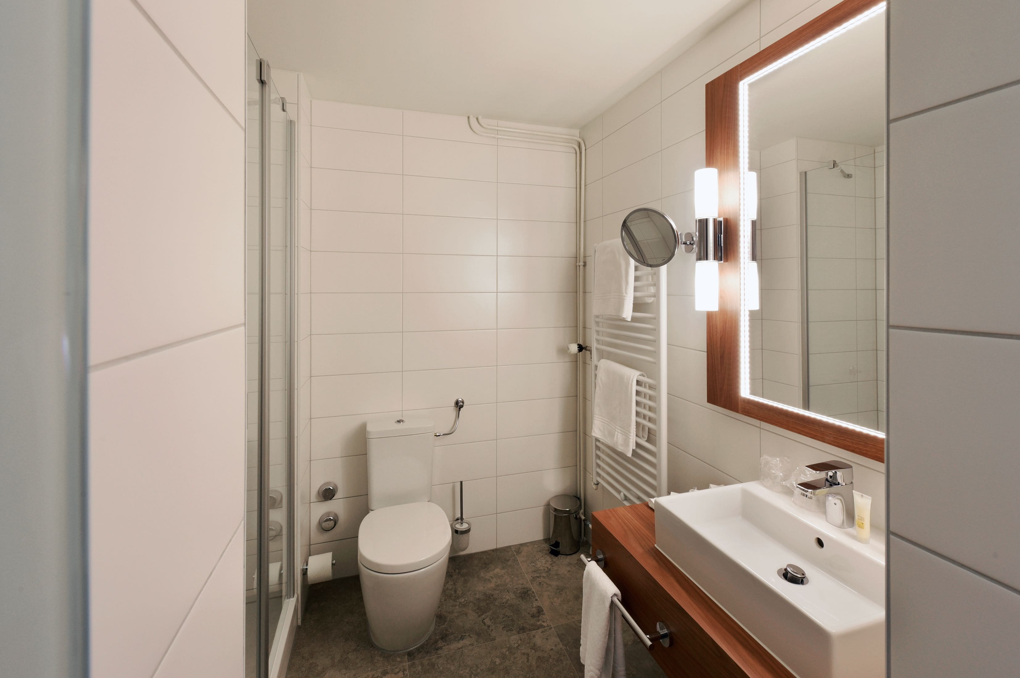 Ein modernes Badezimmer mit Toilette, Waschbecken und Dusche.
