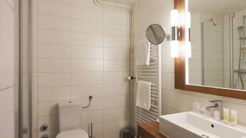 A modern bathroom with a toilet, sink, and mirror.