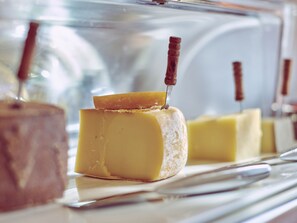 A cheese display with a knife inserted into a wedge of cheese. - Hotel Crystal (Lausanne)