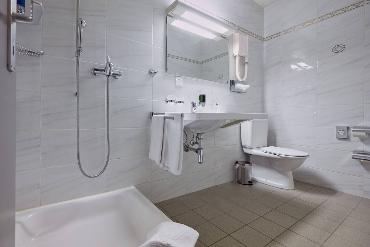 A modern bathroom with a bathtub, a toilet, and a sink.