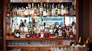 A bar with multiple shelves of liquor bottles and glasses. - Crystal Hotel (St. Moritz)