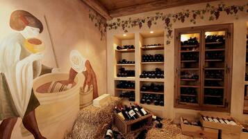A wine cellar with wooden shelves and cabinets, a mural, and a rustic interior.