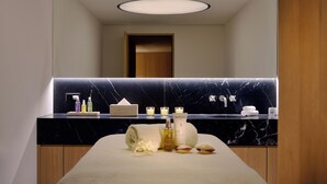 A modern bathroom with a marble countertop, a large mirror, and a towel on the floor. - Crystal Hotel (St. Moritz)