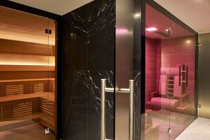 A modern spa room with a wooden bench, a glass partition, and a massage table. - Crystal Hotel (St. Moritz)