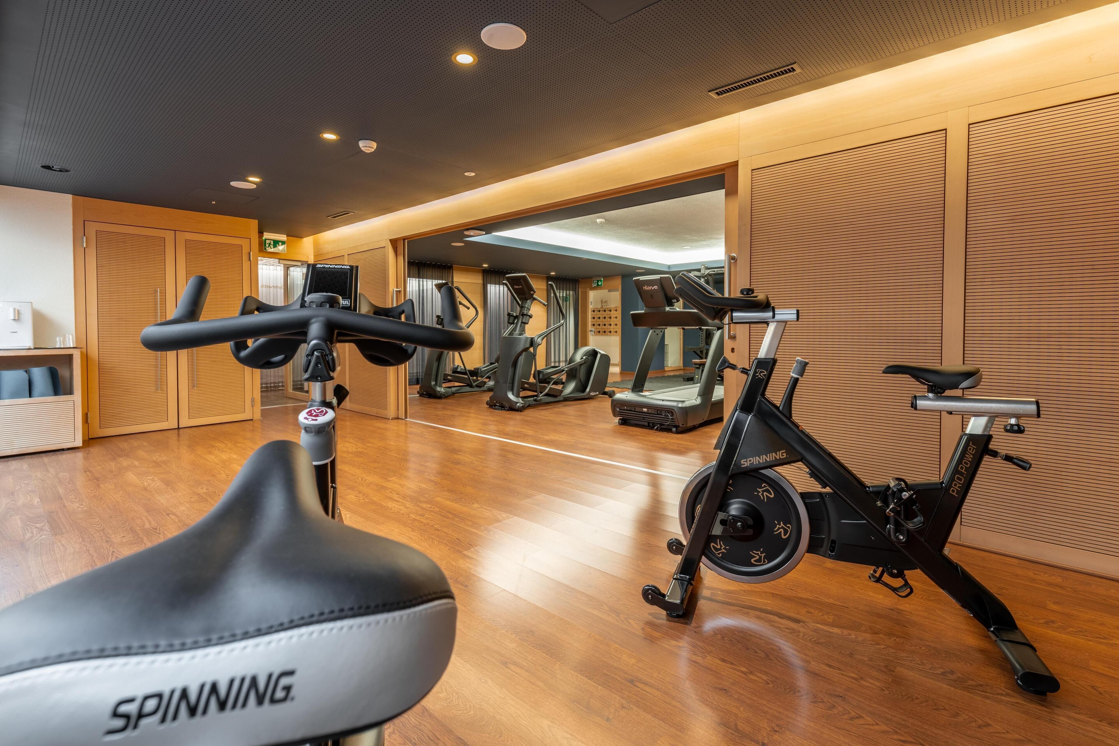 A gym with exercise equipment including a spinning bike and treadmills.