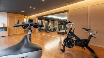 A gym with exercise equipment including a spinning bike and treadmills.