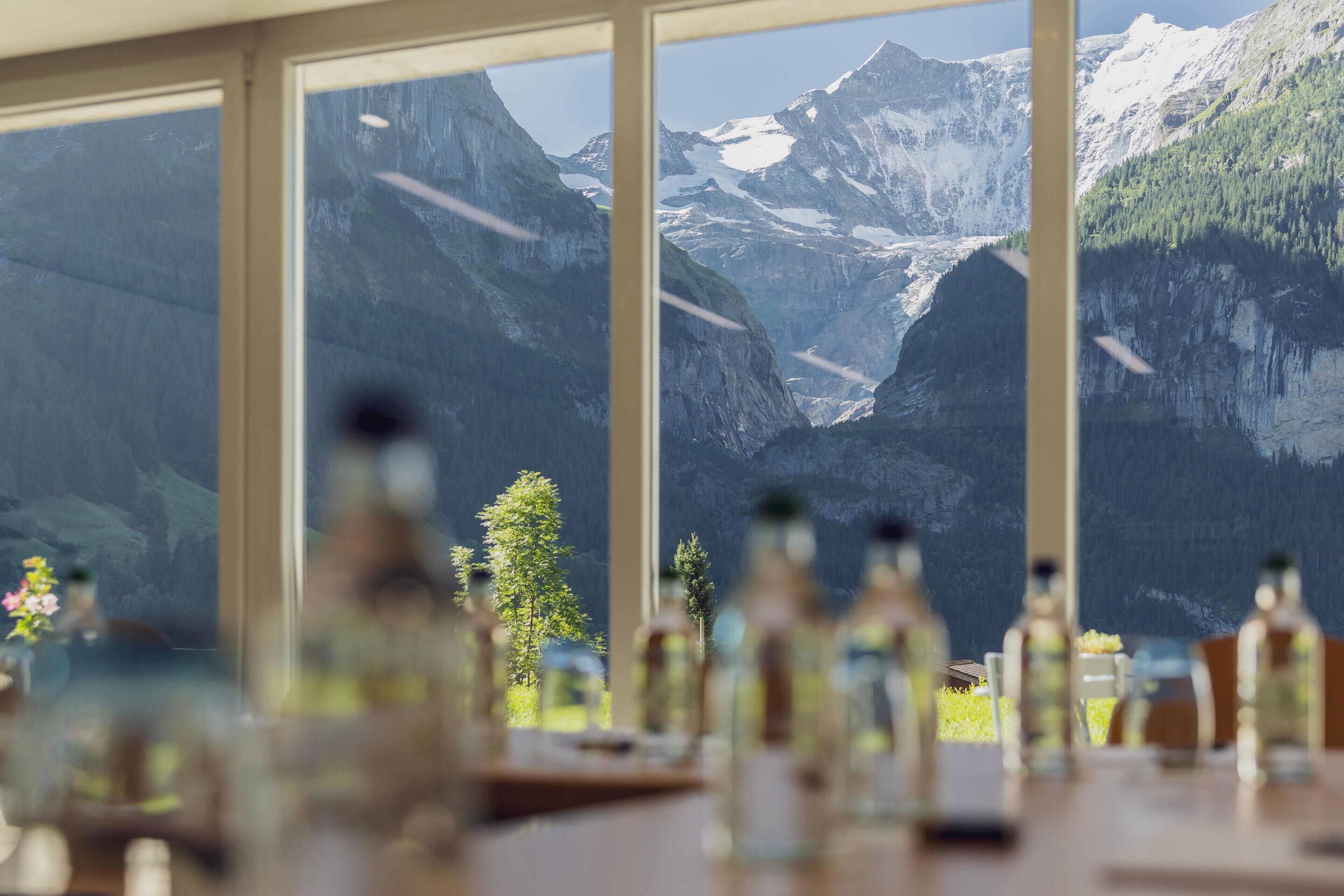 A dining area with a view of a mountainous landscape through large windows.