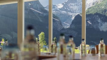 A dining area with a view of a mountainous landscape through large windows.