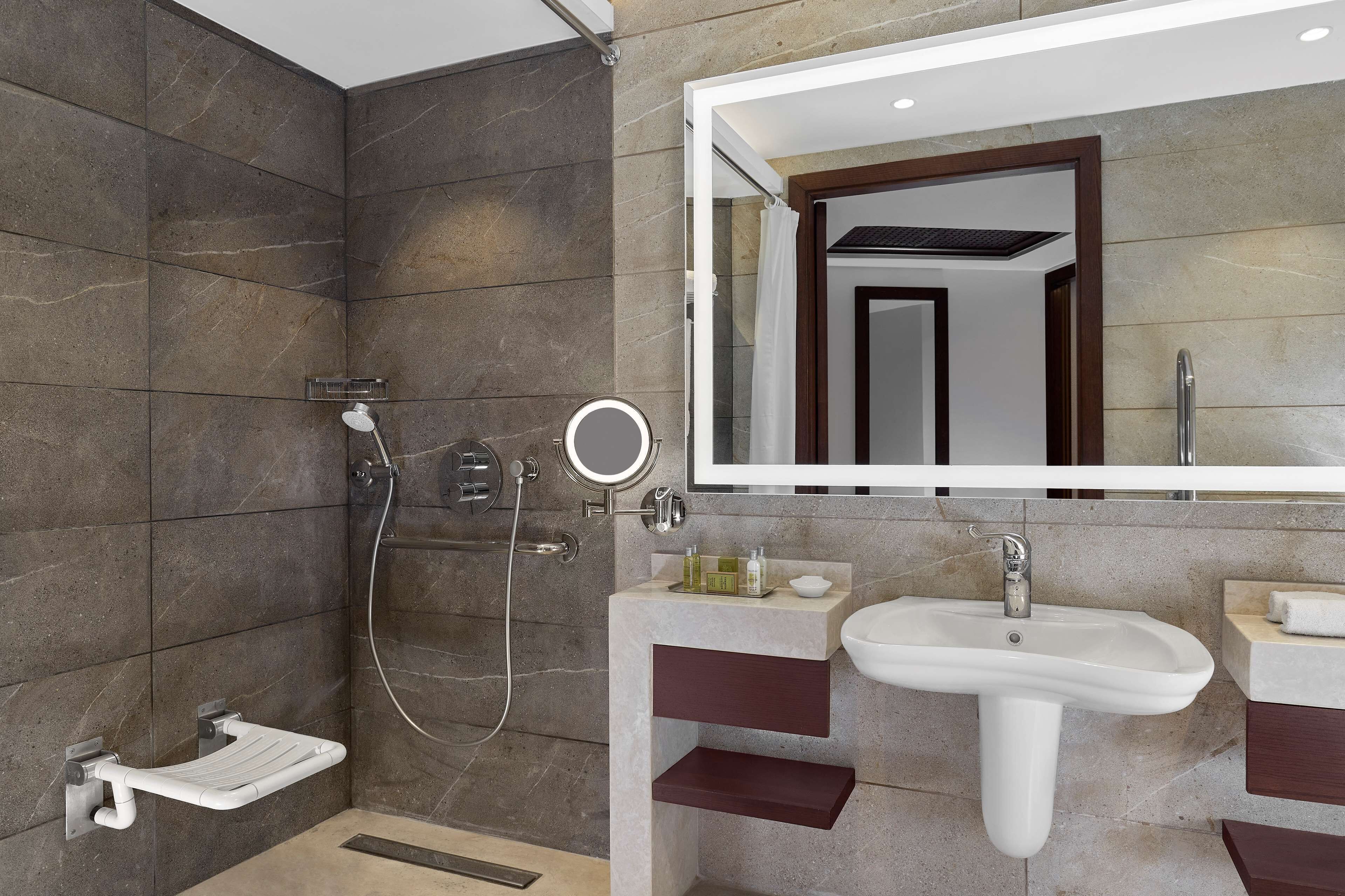 Un baño moderno con cabina de ducha, tocador con lavamanos y espejo.