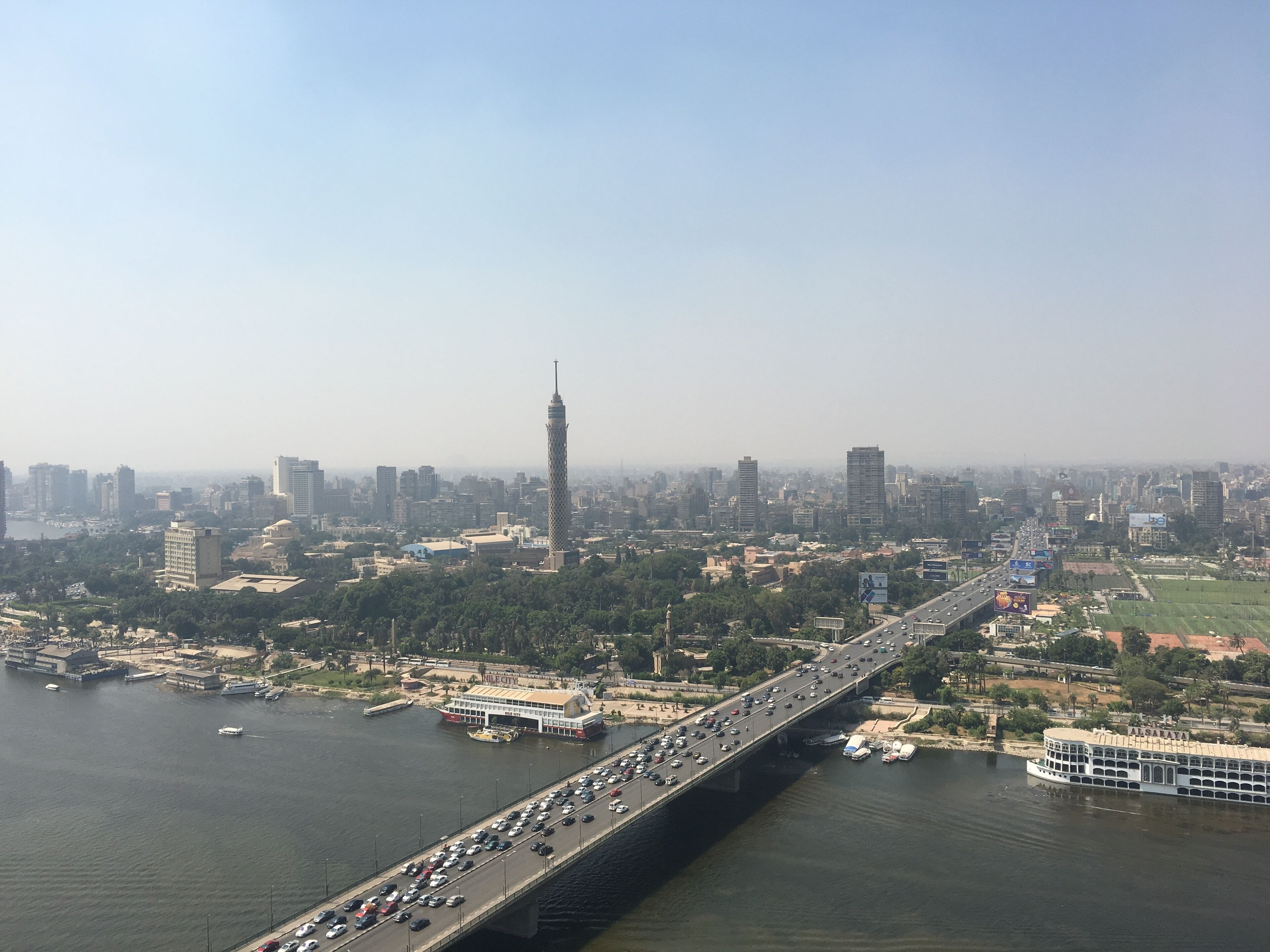 A cityscape with a prominent tower, a busy bridge, and a river.