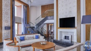 A spacious living area with a sofa set, a coffee table, and a fireplace.