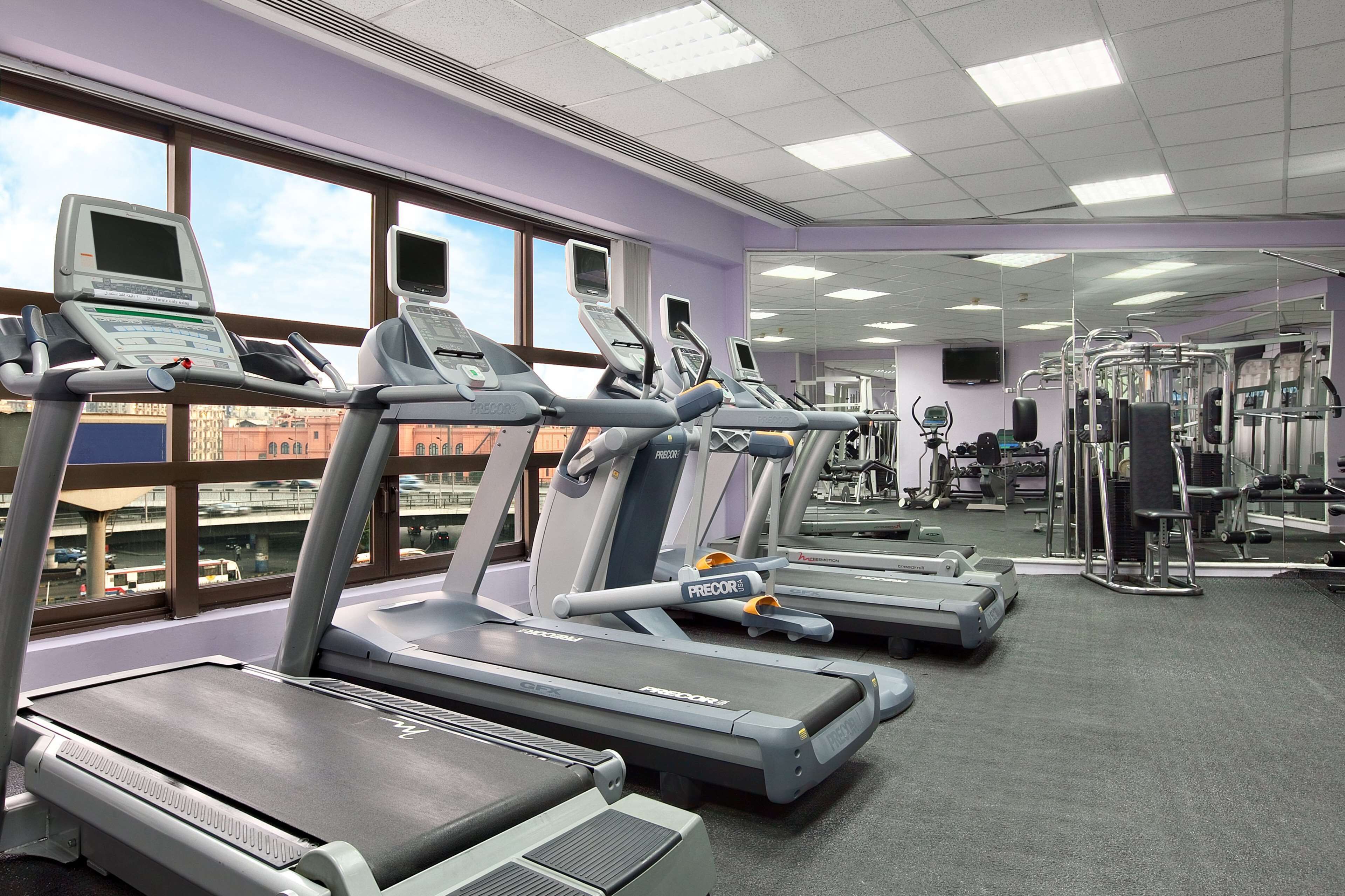 A gym with treadmills, mirrors, and exercise equipment.