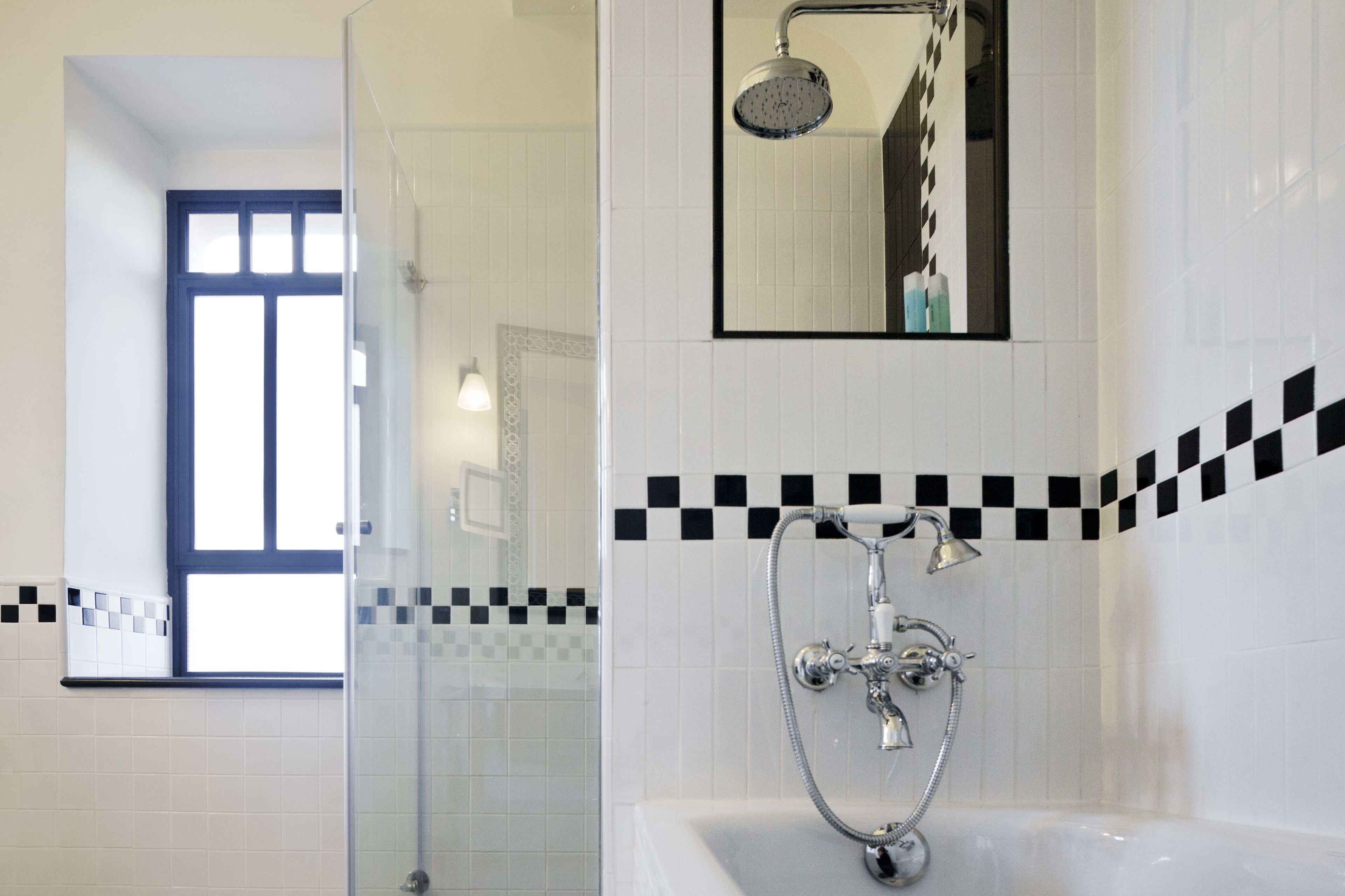 A modern bathroom with a glass-enclosed shower, a bathtub, and a mirror above the sink.