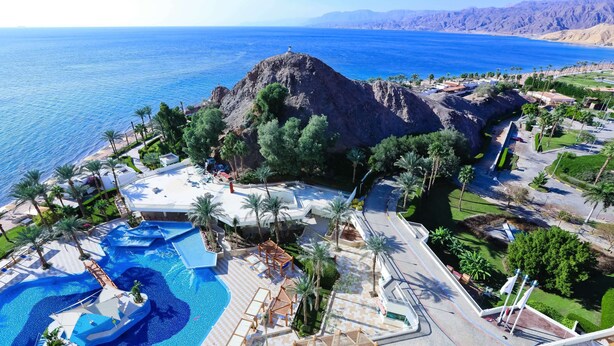 A resort with a pool area, palm trees, and a view of the sea. - Steigenberger Hotel & Nelson Village (Taba)