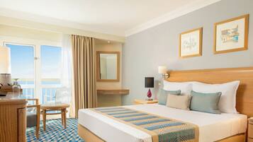 A hotel room with a bed, a desk, a chair, a nightstand, and a window with curtains.