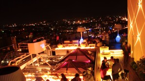 A rooftop bar with a view of the city at night, featuring outdoor seating and ambient lighting. - Grand Palace Hotel (Amman)
