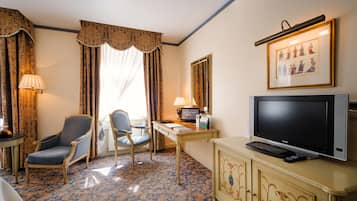 Une chambre d’hôtel équipée d’un bureau, d’une chaise, d’une télévision et d’un lit.