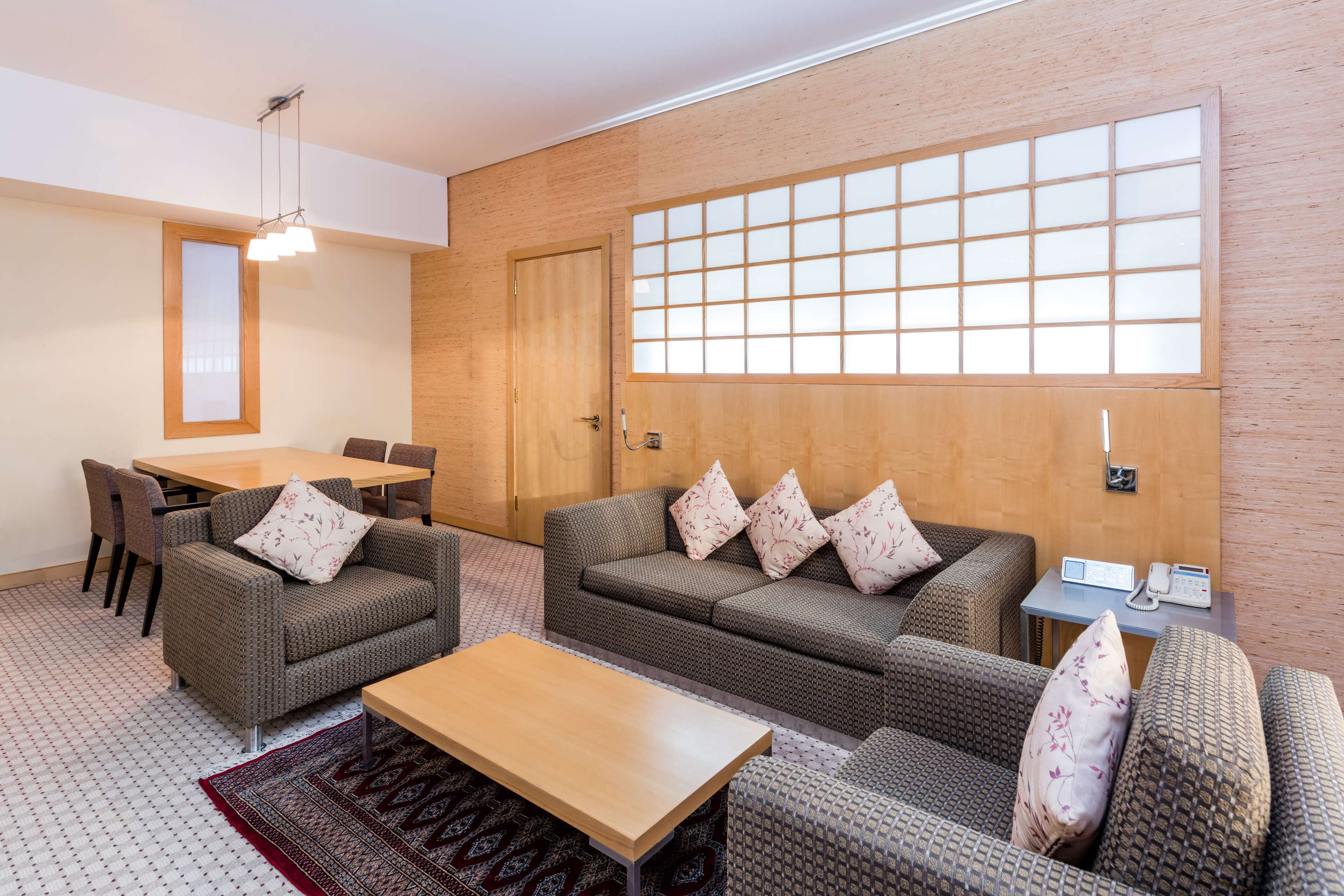 Uma sala de estar moderna com um conjunto de sofá, uma mesa de centro e um espaço de jantar com cadeiras e uma mesa.