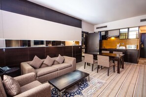 A modern living room with a sofa, coffee table, and dining area.